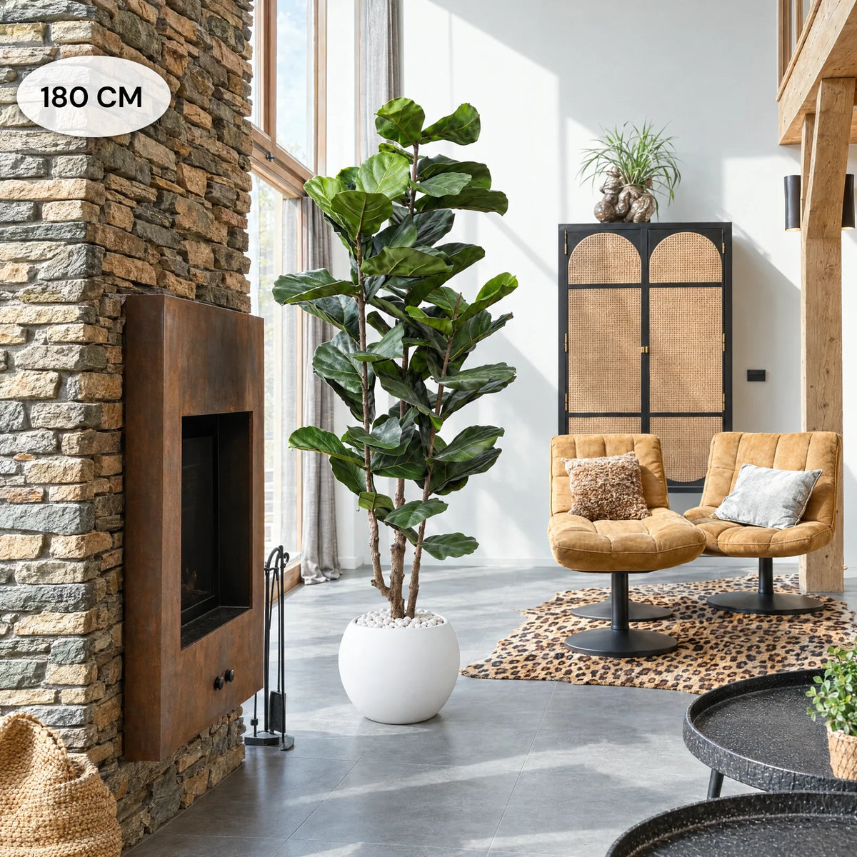 Kunst-Ficus Lyrata 180 cm in weißem Pflanztopf Ø30 cm Kugelform PLENA mit weißen Dekosteinen, im Wohnzimmer neben Natursteinwand und Kamin