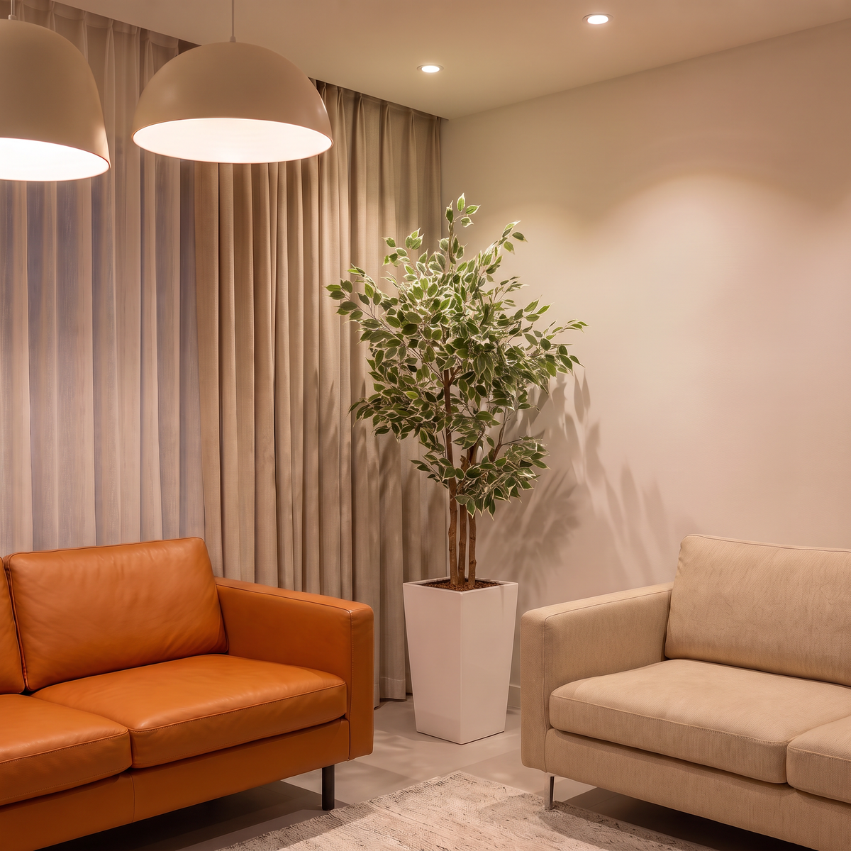 Kunst ficus benjamina 150 cm met decoratieve pot in woonkamer naast oranje leren bank