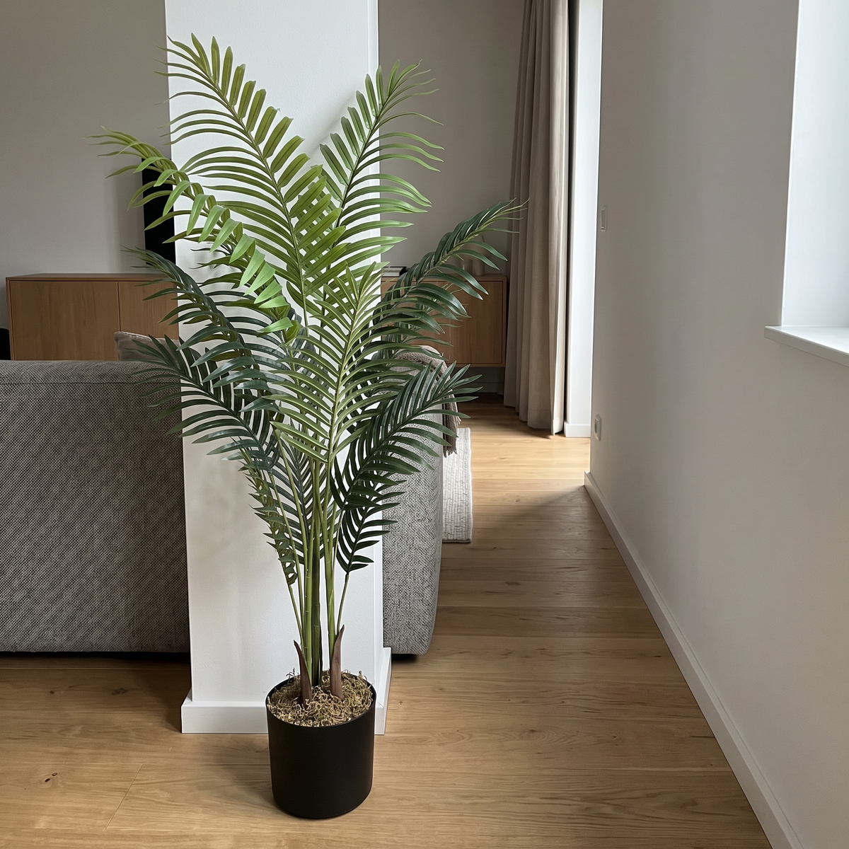 Kunst kentiapalm 180 cm in woonkamer naast de bank