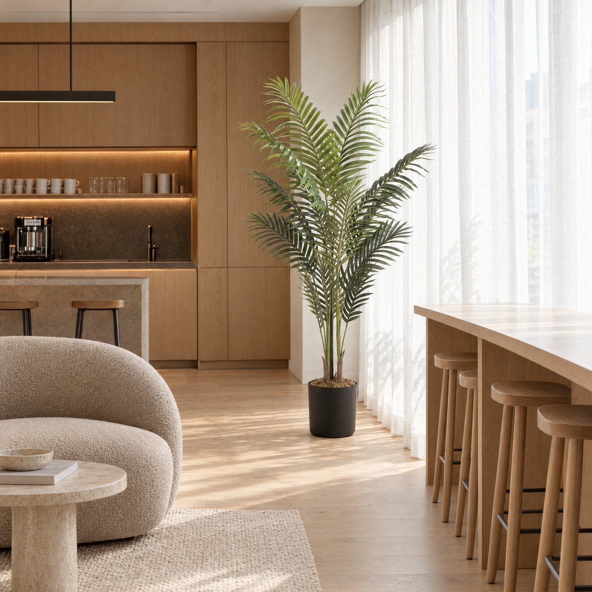 Kunst kentiapalm van 180 cm in zwarte pot bij het raam in een lichte koffiebar met houten barkrukken